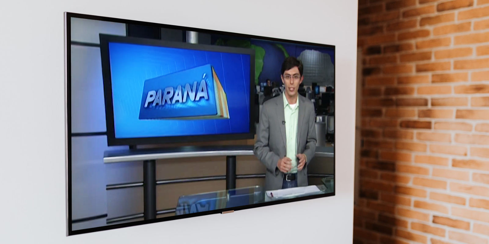 Jovem Simião Castro na bancada do telejornal do Paraná, durante o programa de trainee da RPC TV em 2013